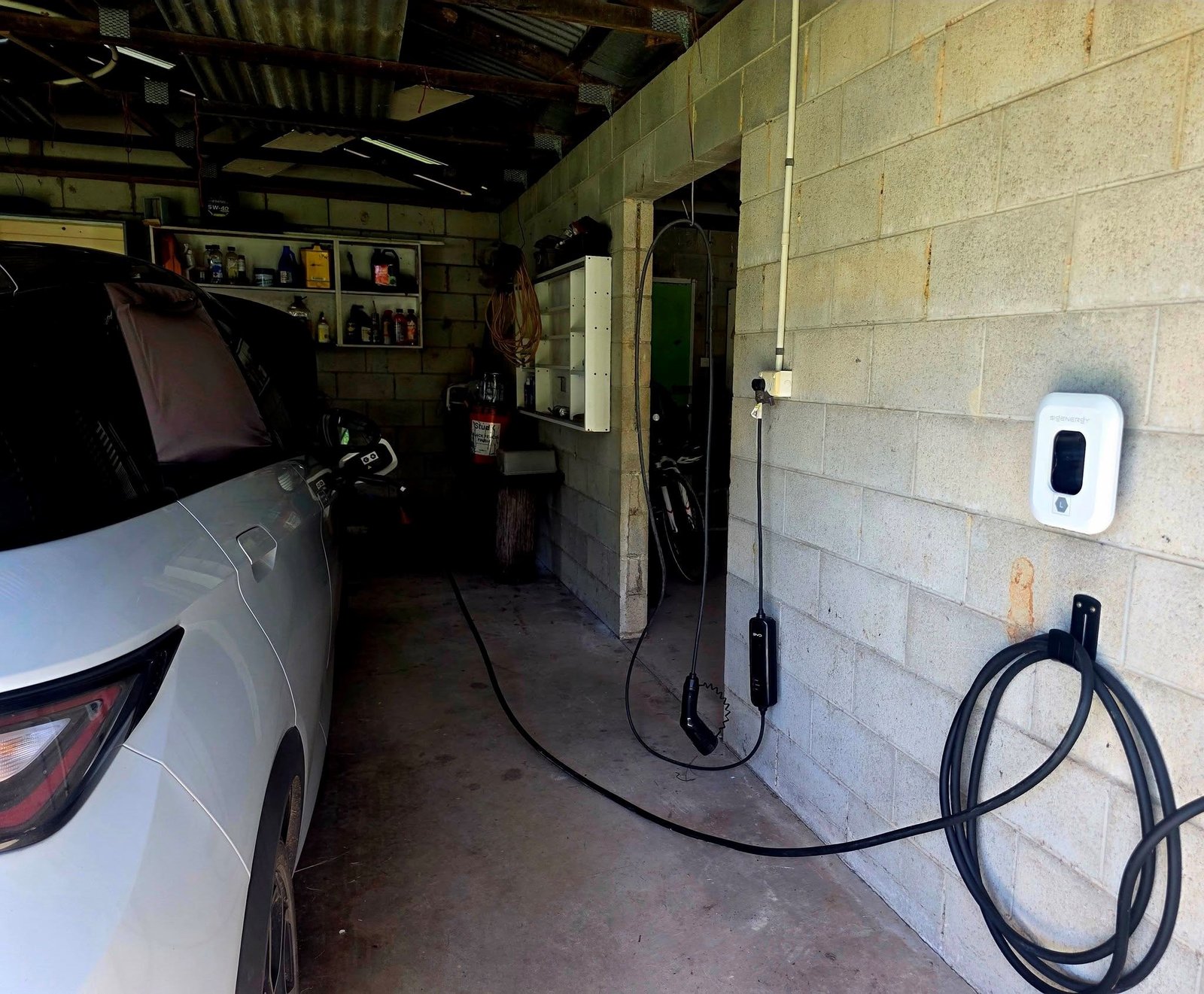 EV parked in a garage next to a Sigenergy charger